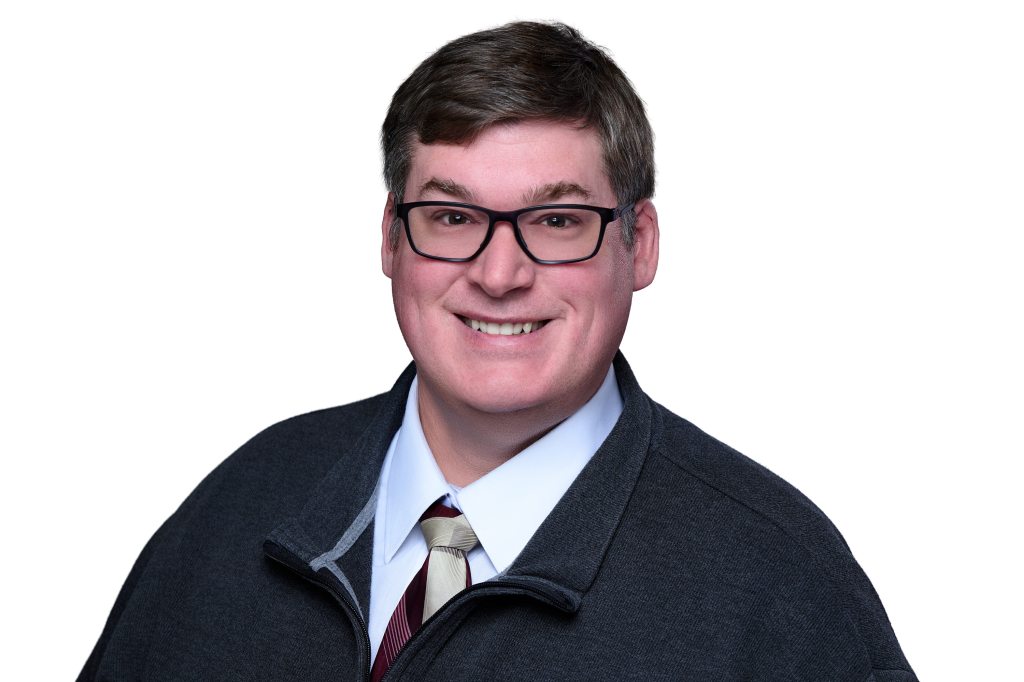 Profile Image of Michael Kane smiling at the camera with a white background.